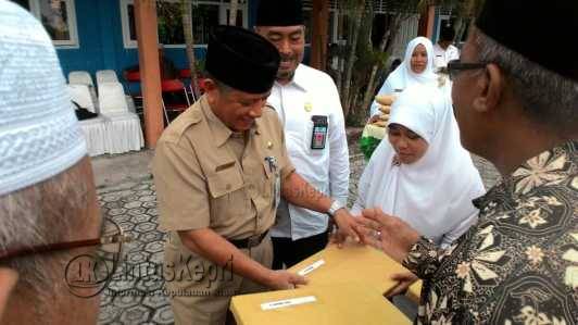 Asisten II Pemkab Natuna, Abdullah saat memberikan santunan kepada pensiunan didampingi Kepala Kantor Kemenag Kabupaten Natuna, Sudarmadi, S. Ag.